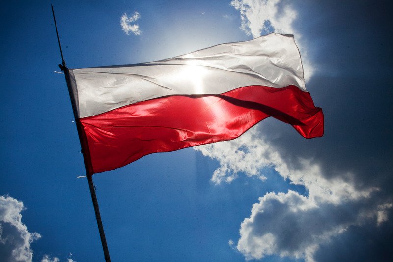 Biało-czerwona flaga na tle zachmurzonego nieba