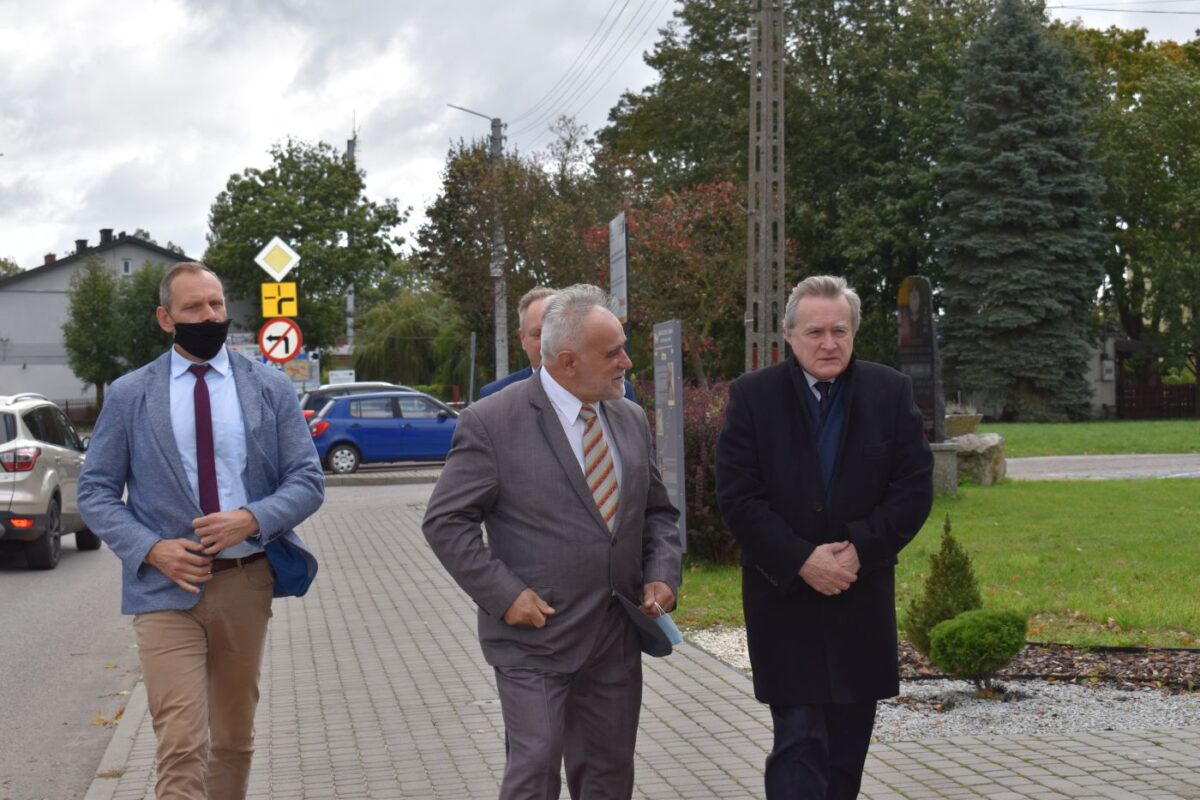Trzech mężczyzn idących chodnikiem.