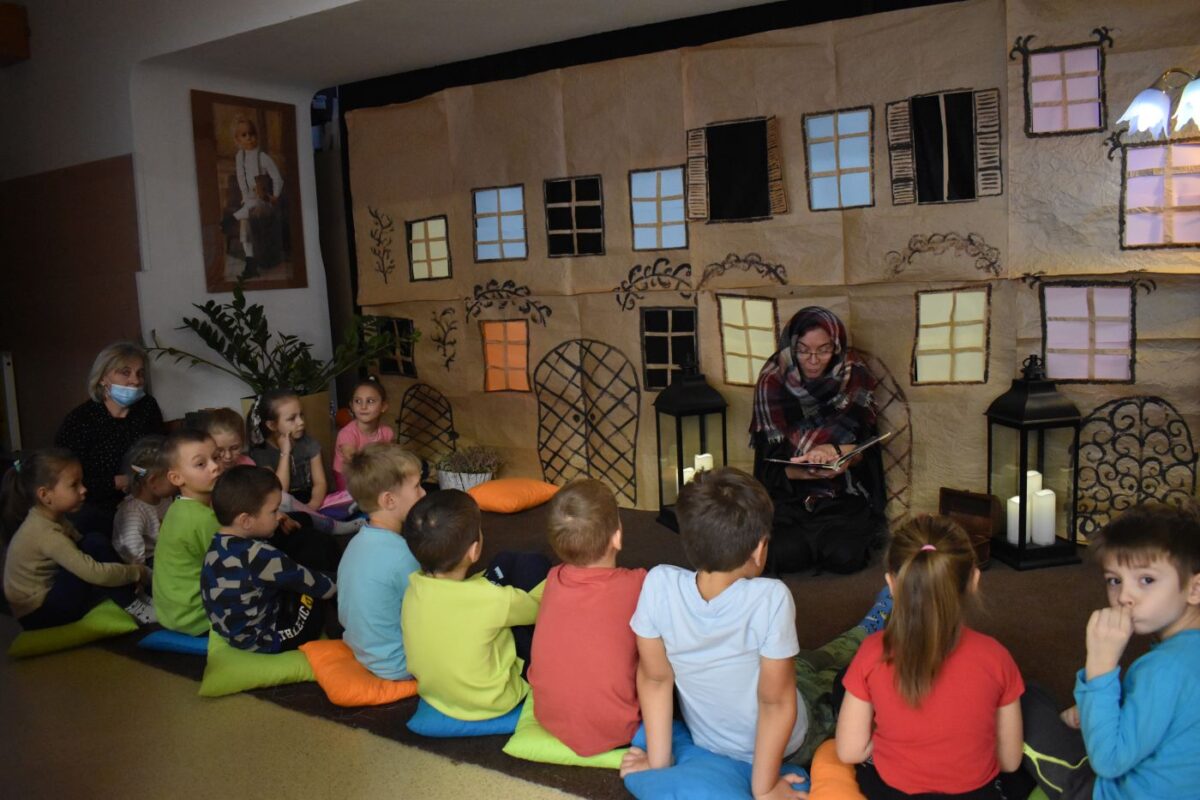 Dzieci i opiekunka na tle dekoracji