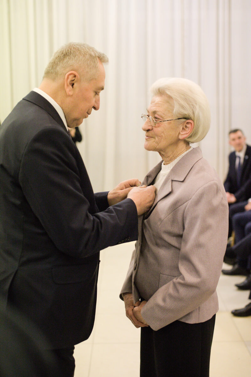 Mężczyzna wręczający kobiecie odznakę