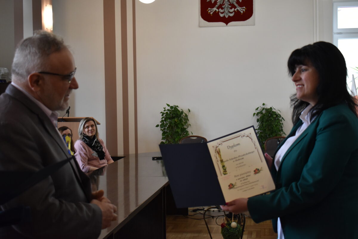 Mężczyzna wręczający kobiecie dyplom