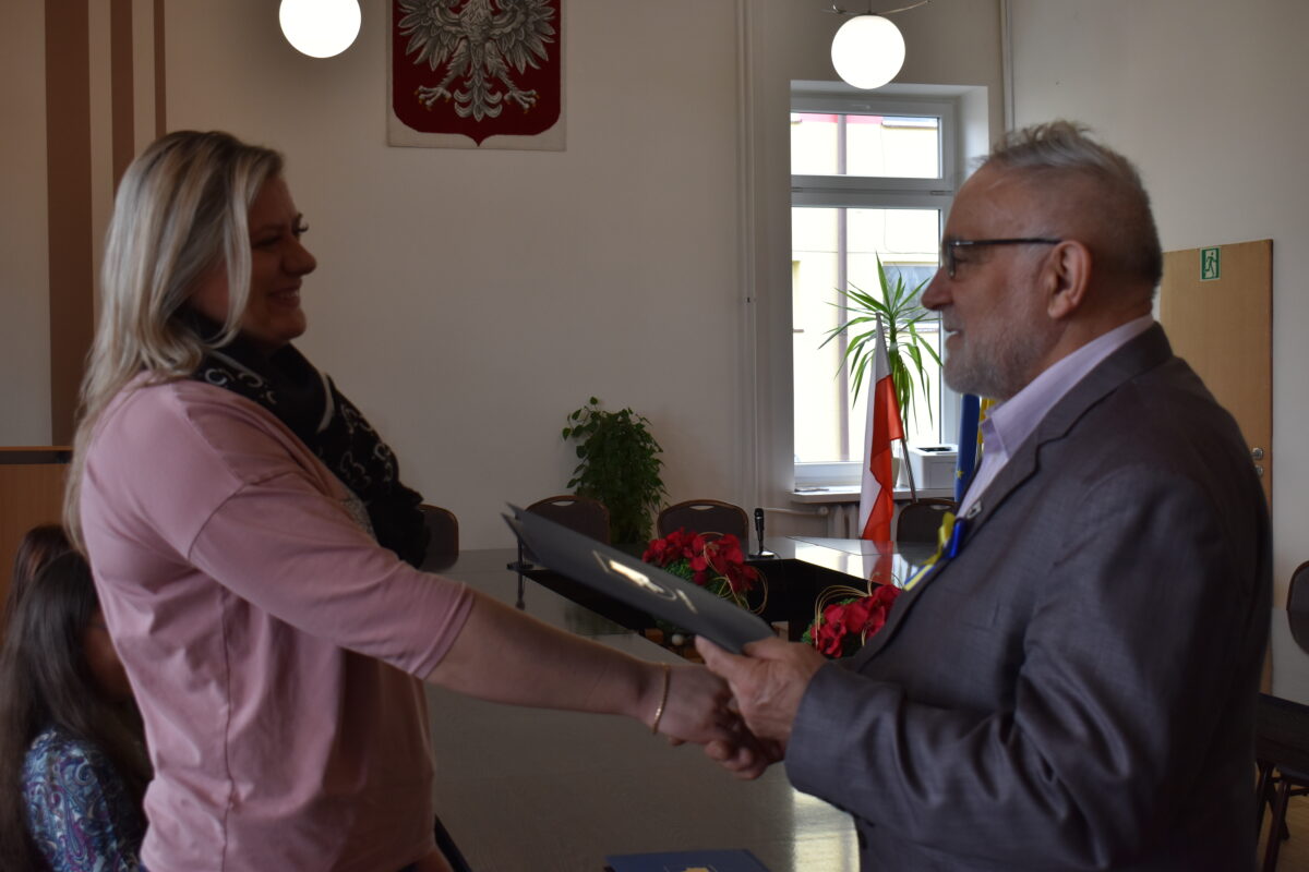 Mężczyzna wręczający kobiecie dyplom