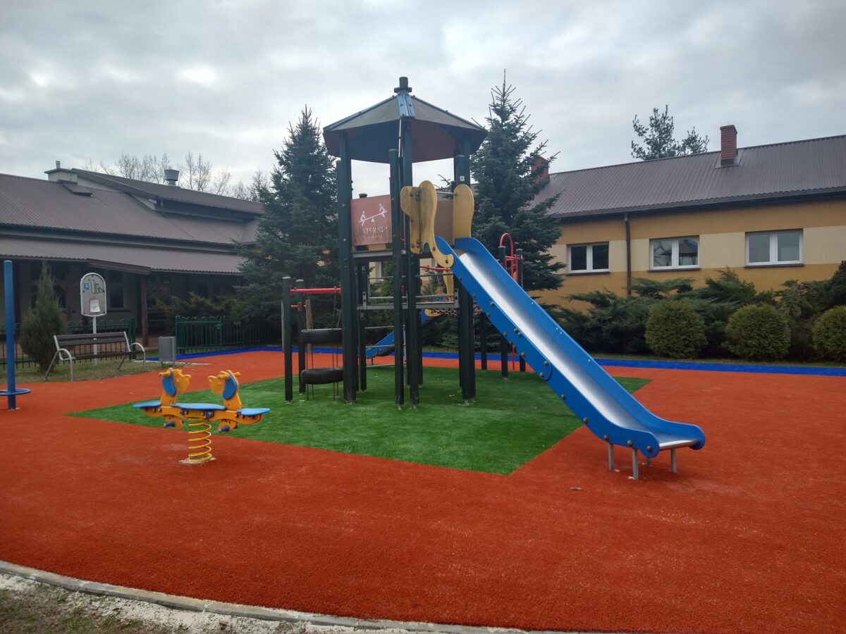Niebieska zjeżdżalnia, w tle żółty budynek