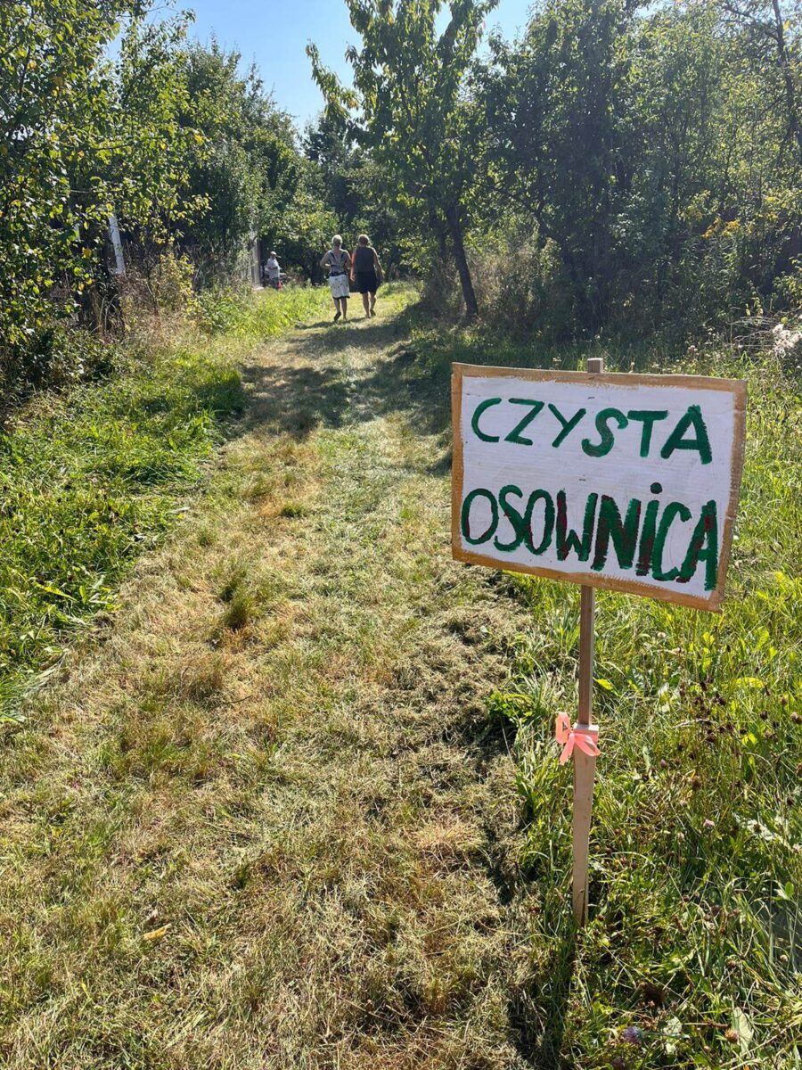 tabliczka Czysta Osownica wbita w łąkę