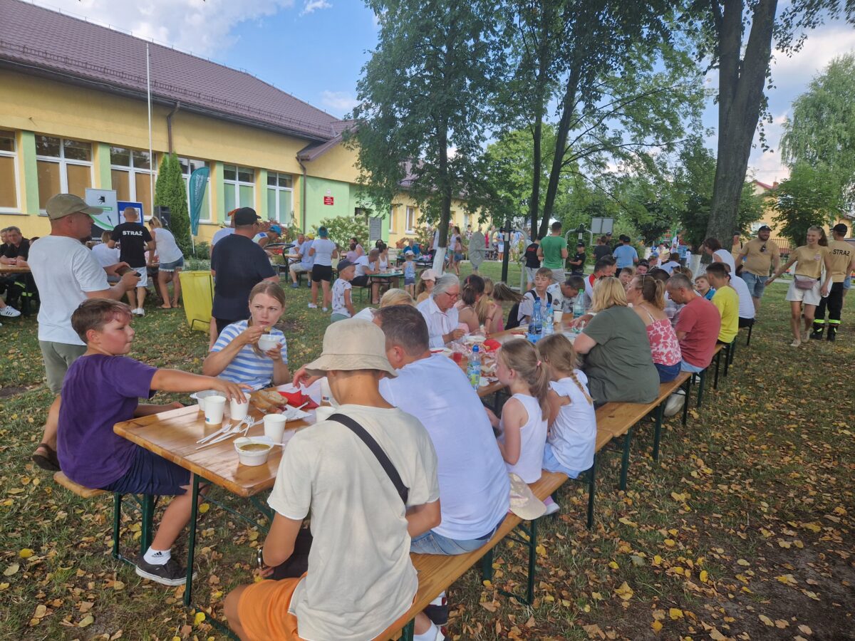 stoły i ławki zajęte przez ludzi
