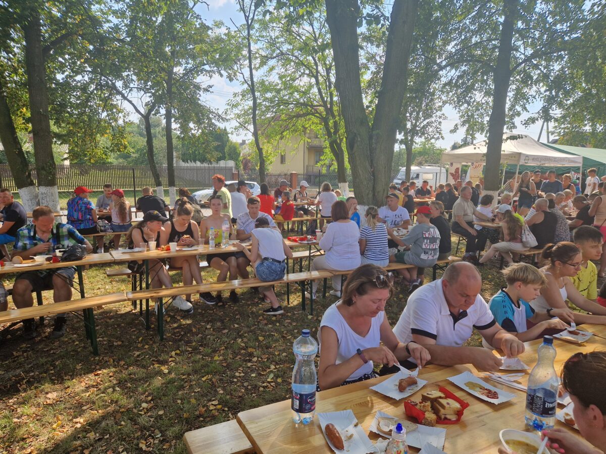 stoły i ławki zajęte przez ludzi