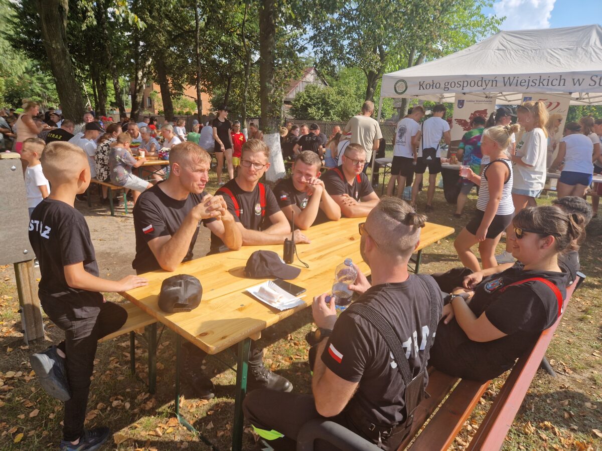 stoły i ławki zajęte przez ludzi