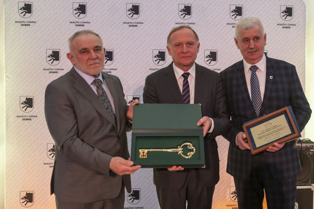 Grupa mężczyzn trzymających klucz i tabliczkę.