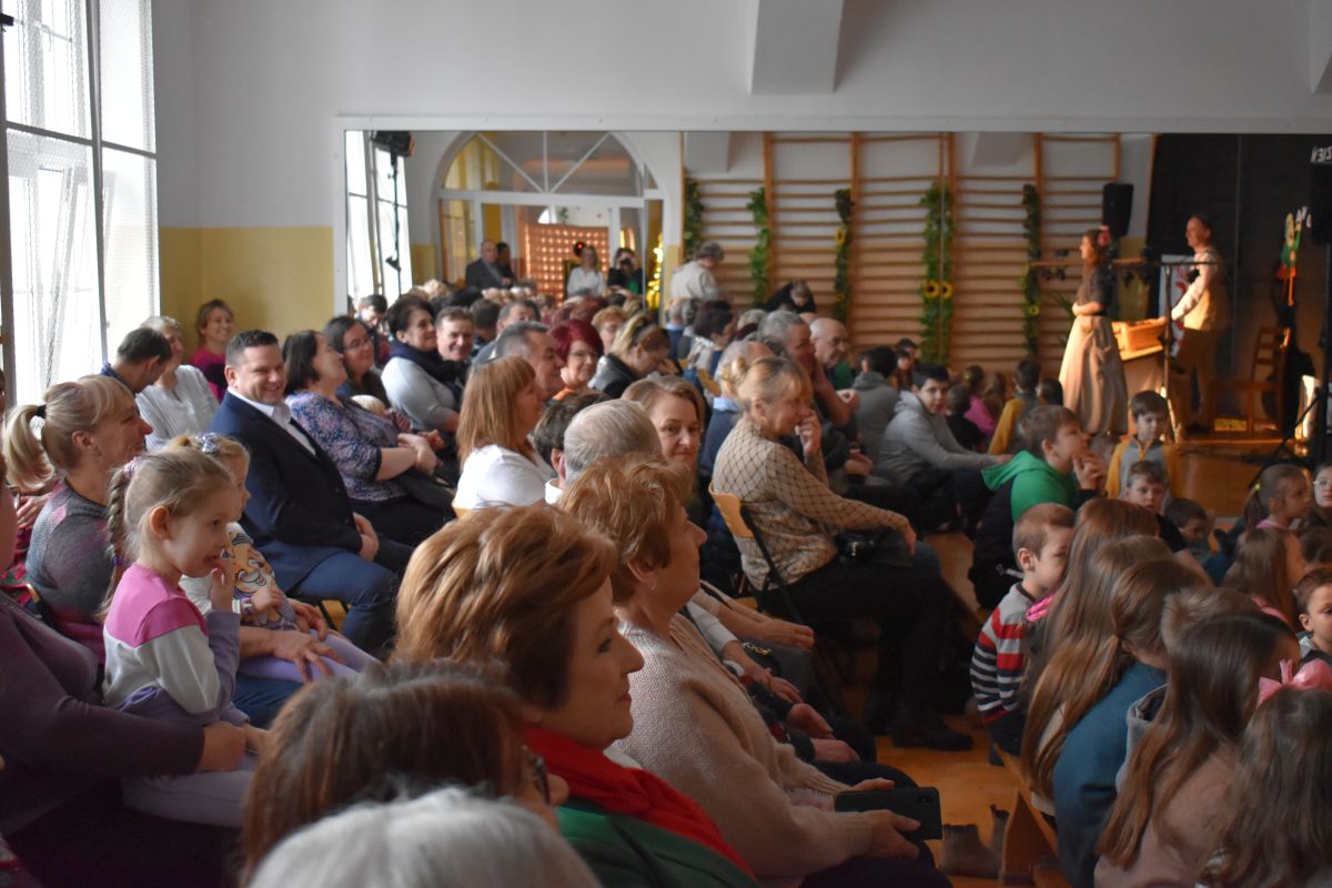 Na udostępnienie jest grupa ludzi siedzących w pomieszczeniu. Wydają się być skupieni, co może sugerować spotkanie, seminarium lub inną formę zbiorowego zgromadzenia.