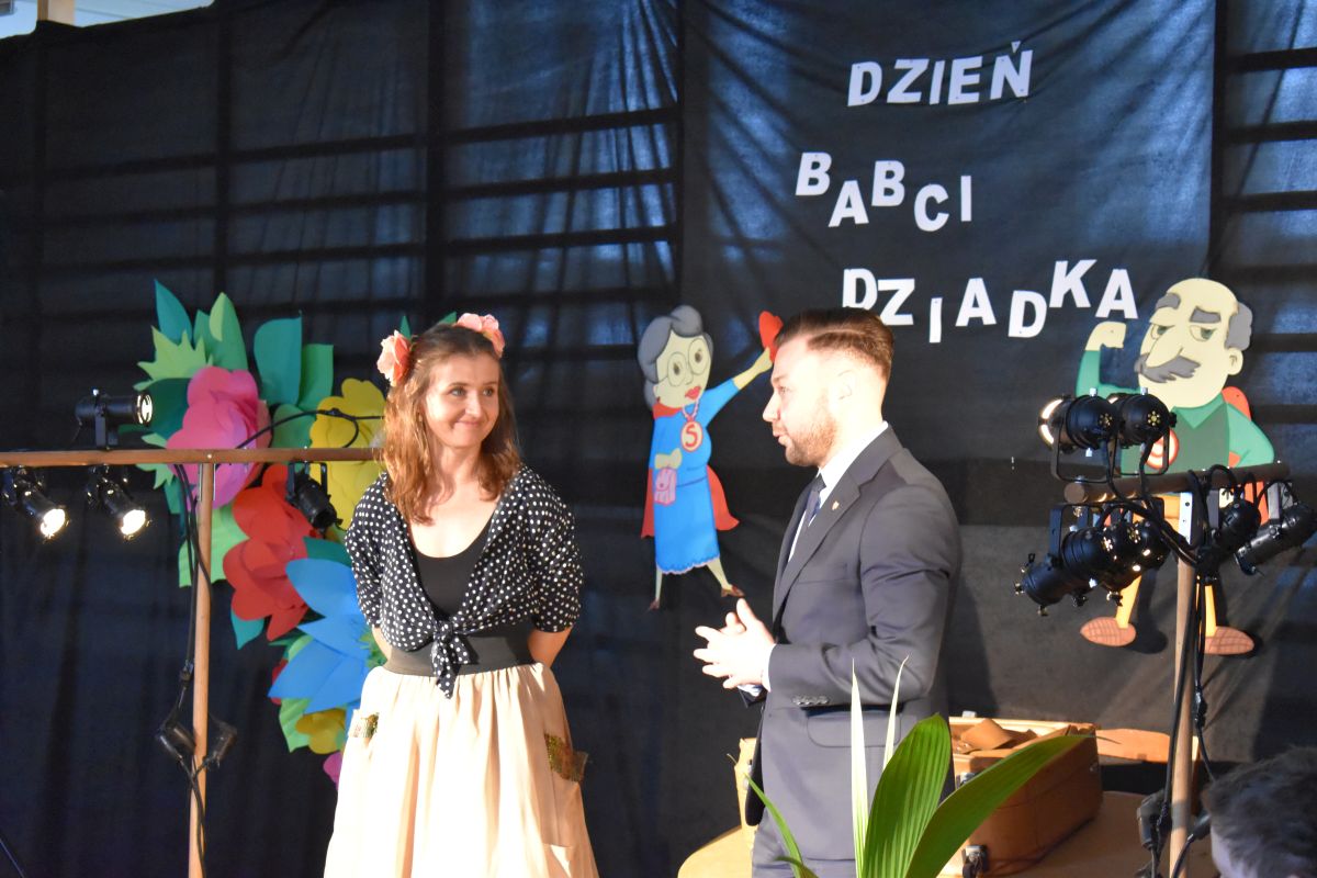Na zdjęciu stojących obok siebie mężczyzn i kobiet. Wyglądają na towarzyszących sobie, co szczególne ich bliskie położenie względem siebie.