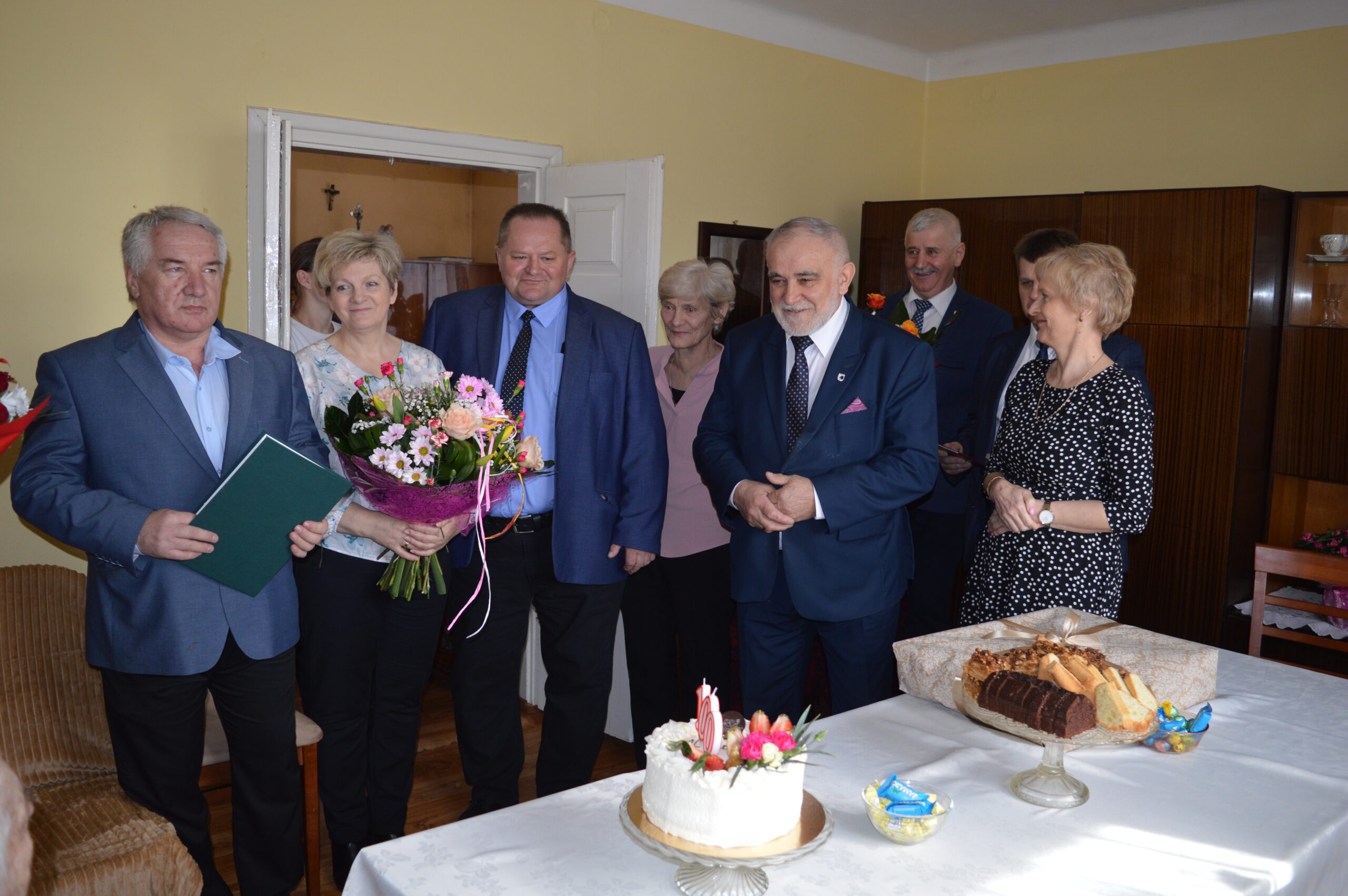 Na zdjęciu widać grupę eleganckich dorosłych, którzy zgromadzili się w pomieszczeniu. Na sto tort, co francuskie, że są łatwo dostępne.